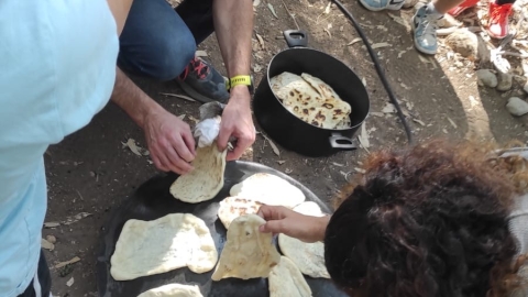 תלמידי קרוב מכינים פיתות בשטח כחלק ממחנה במדבר.jpeg